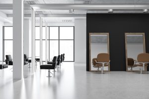 Interior of a modern barber shop with a concrete floor, tall mirrors, white columns and black comfortable chairs. White and black walls. 3d rendering